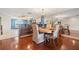 Open dining area with stylish chandelier, wood floors, and connection to the kitchen at 751 Pinellas Bayway S # 104, St Petersburg, FL 33715