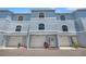 Charming townhome with a well-kept facade featuring a garage and landscaped entrance and light blue exterior at 751 Pinellas Bayway S # 104, St Petersburg, FL 33715
