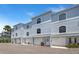 Well-maintained townhome featuring attached garages and a light blue exterior against a clear blue sky at 751 Pinellas Bayway S # 104, St Petersburg, FL 33715