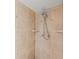 Close-up of shower with custom tile, shower head, and built in storage shelves at 751 Pinellas Bayway S # 104, St Petersburg, FL 33715