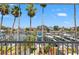 Balcony view of waterfront with boats docked below and palm trees on the horizon at 751 Pinellas Bayway S # 104, St Petersburg, FL 33715