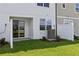 Close up of the townhome backyard featuring a green lawn and sliding glass doors at 7683 Deer Valley Circle, Tampa, FL 33635