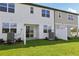 Townhome backyard with green lawn, privacy fence, and sliding glass door entrance at 7683 Deer Valley Circle, Tampa, FL 33635