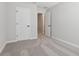 An empty bedroom with plush carpeting and white doors, offering a clean, modern space for personalization at 7683 Deer Valley Circle, Tampa, FL 33635