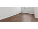 Empty bedroom features wood-look floors, white walls and baseboards, and a bright window at 7683 Deer Valley Circle, Tampa, FL 33635