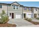 Townhome exterior featuring attached garages, brick driveway, and colorful siding details at 7683 Deer Valley Circle, Tampa, FL 33635