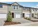 Townhome exterior featuring attached garages, brick driveway, and colorful siding details at 7683 Deer Valley Circle, Tampa, FL 33635