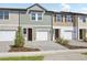 Townhome exterior featuring attached garages, brick driveway, and colorful siding details at 7683 Deer Valley Circle, Tampa, FL 33635