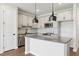 Modern kitchen with stainless steel appliances, gray cabinets, pendant lighting, and center island at 7683 Deer Valley Circle, Tampa, FL 33635