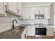 Close up view of kitchen with stainless sink, gray countertops, stainless oven and tile backsplash at 7683 Deer Valley Circle, Tampa, FL 33635