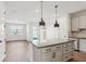 Kitchen island, stainless appliances, with open floorplan into living area and wood-look flooring at 7683 Deer Valley Circle, Tampa, FL 33635