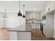 Kitchen view with stainless appliances, gray countertops, island and open floorplan into living area at 7683 Deer Valley Circle, Tampa, FL 33635