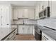 Kitchen with stainless appliances, gray countertops, tile backsplash, and wood-look flooring at 7683 Deer Valley Circle, Tampa, FL 33635