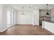 Open-concept living area with wood-look tile flooring, modern chandelier, and bright, neutral paint at 7683 Deer Valley Circle, Tampa, FL 33635
