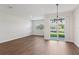 Open-concept room with wood-look tile flooring, a large window, and backyard views at 7683 Deer Valley Circle, Tampa, FL 33635