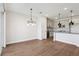 Open-concept living area with wood-look tile flooring, modern chandelier, and views of kitchen at 7683 Deer Valley Circle, Tampa, FL 33635