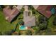 Aerial view showcases a home with a backyard pool, lush greenery, and neighboring residences at 8604 Herons Cove Pl, Tampa, FL 33647
