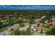 An aerial view of a neighborhood with mature trees, ponds, and well-maintained homes at 8604 Herons Cove Pl, Tampa, FL 33647