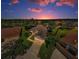 An aerial view of a home with a driveway, lush landscaping, and a well-maintained lawn at sunset at 8604 Herons Cove Pl, Tampa, FL 33647