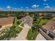 An aerial view of a home with a driveway, lush landscaping, and a well-maintained lawn on a sunny day at 8604 Herons Cove Pl, Tampa, FL 33647