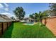 A lush backyard features a sparkling pool, enclosed by brick and wood fencing at 8604 Herons Cove Pl, Tampa, FL 33647