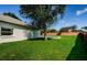 Green lawn backyard featuring a tranquil pool surrounded by mature trees and fencing at 8604 Herons Cove Pl, Tampa, FL 33647