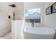 Bathroom features a soaking tub and walk-in shower under a bright window at 8604 Herons Cove Pl, Tampa, FL 33647