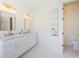 Bright bathroom featuring a double vanity with marble countertops and gold fixtures at 8604 Herons Cove Pl, Tampa, FL 33647