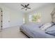 Well-lit bedroom with a ceiling fan, access to the outdoors, and bright tile floors at 8604 Herons Cove Pl, Tampa, FL 33647