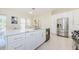 Modern kitchen features a marble island, white cabinets with gold hardware, and stainless appliances at 8604 Herons Cove Pl, Tampa, FL 33647