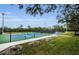 Multiple fenced tennis courts with green and blue surfaces, a sidewalk and surrounding greenery, enhance recreation at 8604 Herons Cove Pl, Tampa, FL 33647