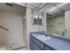 Bathroom features a walk-in shower, a sink with blue vanity and large mirror, with a tiled floor at 8990 Antigua Dr, Seminole, FL 33777