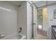 Bathroom with a shower and tub combo, white tile, and access to another room at 8990 Antigua Dr, Seminole, FL 33777