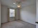 Bedroom featuring a ceiling fan, neutral carpeting, and a window with curtains allowing natural light at 8990 Antigua Dr, Seminole, FL 33777