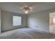 Bright bedroom featuring a ceiling fan, window with blinds, and neutral carpeting at 8990 Antigua Dr, Seminole, FL 33777