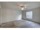 A well-lit bedroom showcasing neutral walls, carpeting, and a window with horizontal blinds at 8990 Antigua Dr, Seminole, FL 33777
