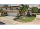 Exterior view of a two-story townhouse featuring a two-car garage and a landscaped front yard at 8990 Antigua Dr, Seminole, FL 33777