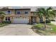 Two-story townhouse with a two-car garage, tidy landscaping, and a welcoming front entrance at 8990 Antigua Dr, Seminole, FL 33777