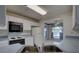 Functional kitchen featuring white cabinets, stainless steel sink, and view into the breakfast nook at 8990 Antigua Dr, Seminole, FL 33777
