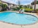 Community pool with lounge chairs in a lush green setting at 8990 Antigua Dr, Seminole, FL 33777