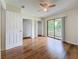 Bright bedroom featuring hardwood floors, ceiling fan, closet and sliding glass doors to a balcony at 22706 Gage Loop # 31, Land O Lakes, FL 34639