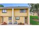 Charming two-story condo with yellow siding, white trim, and a cozy fenced patio, offering a welcoming exterior at 22706 Gage Loop # 31, Land O Lakes, FL 34639