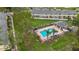 Aerial view of a community pool with a cabana, lounge chairs, and lush landscaping at 22706 Gage Loop # 31, Land O Lakes, FL 34639