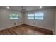 Bright bedroom features two windows, ceiling fan, and wood-look flooring at 1027 Fountainhead Dr, Largo, FL 33770