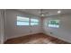 Bright bedroom with two windows, ceiling fan, and wood-look flooring at 1027 Fountainhead Dr, Largo, FL 33770