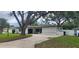 Charming home featuring a well-maintained lawn, and ample parking space with mature shade trees at 1027 Fountainhead Dr, Largo, FL 33770