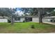 Inviting home with green lawn, complemented by mature trees and a white perimeter fence at 1027 Fountainhead Dr, Largo, FL 33770