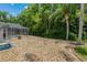The backyard shows stone landscaping, mature trees, and an inviting screened pool area at 1046 Middlesex Dr, New Port Richey, FL 34655