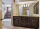 Bathroom featuring a dual sink vanity with granite countertops and updated lighting at 1046 Middlesex Dr, New Port Richey, FL 34655