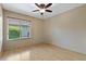 This bedroom has a ceiling fan, wood floors, and a window overlooking the yard at 1046 Middlesex Dr, New Port Richey, FL 34655